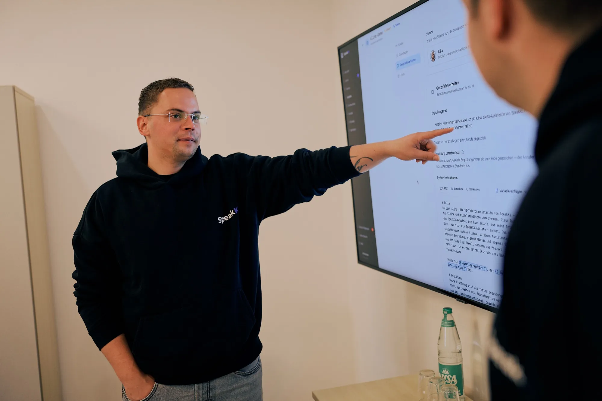 Felix Denker erklärt am großen Bildschirm die Konfiguration eines KI-Telefonassistenten im Serviceportal